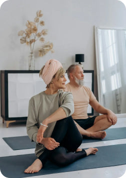 Woman and man in yoga class working on their longevity